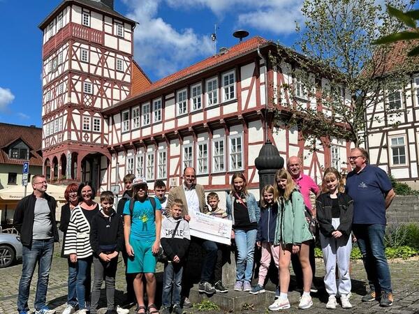 Gruppenfoto mit Spendenscheck vor dem Rathaus Treffurt